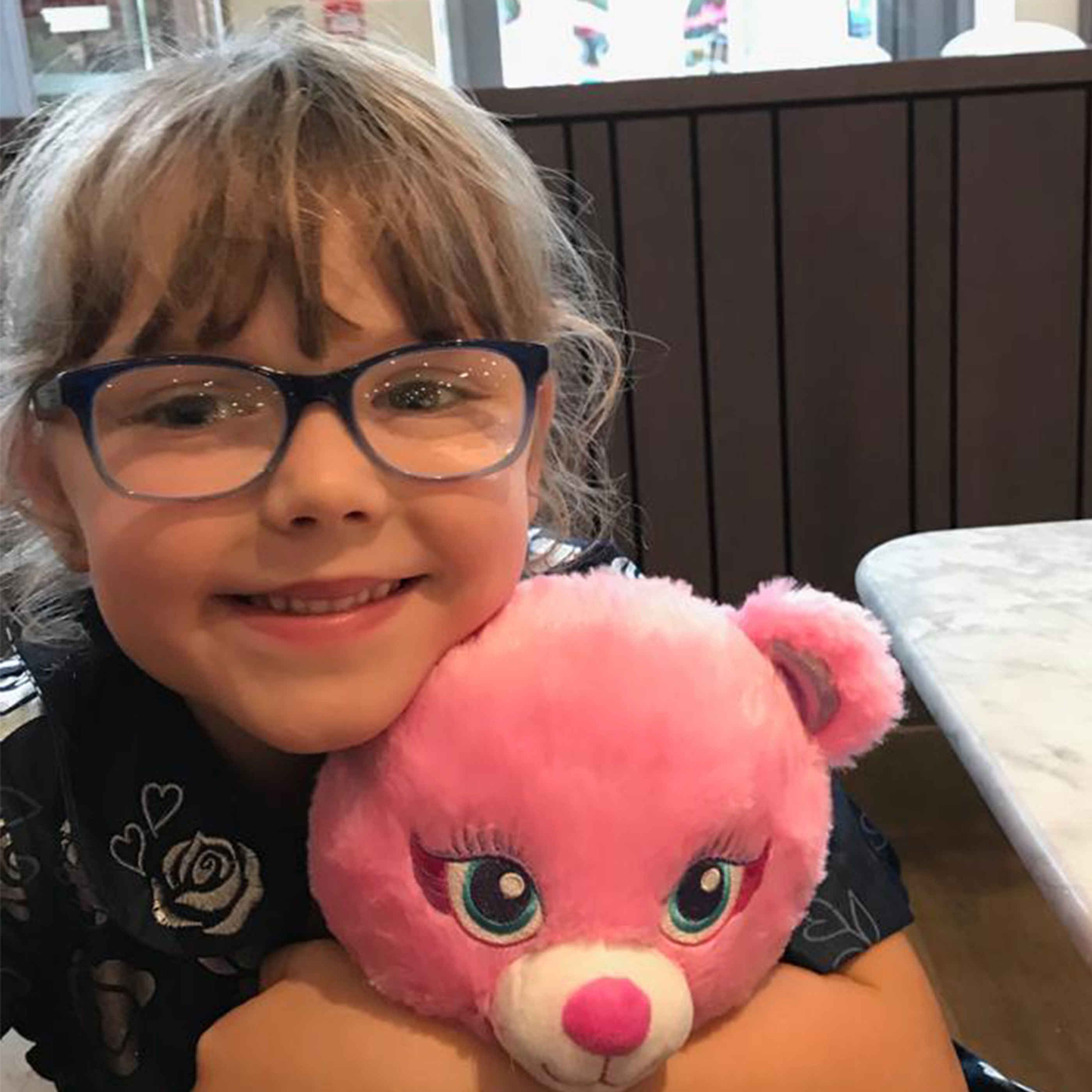 Matilda smiling with pink teddy