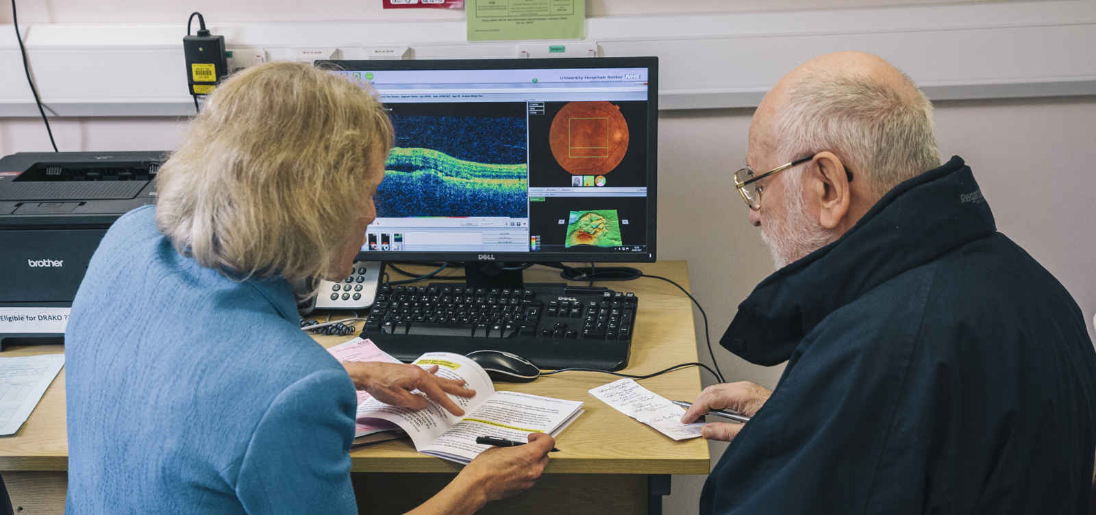 Female consultant, discussing results with male patient with computer images of results.