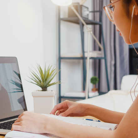 Young woman with headphones watching a video on a laptop