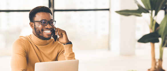 Man smiling on phone at desk