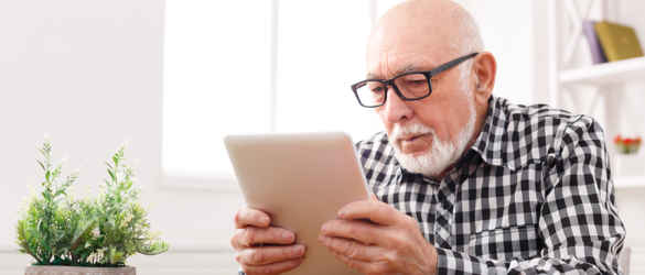 Man with glasses, looking at tablet
