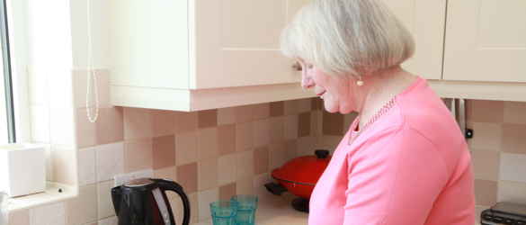 Older lady cutting tomatoes on chopping board